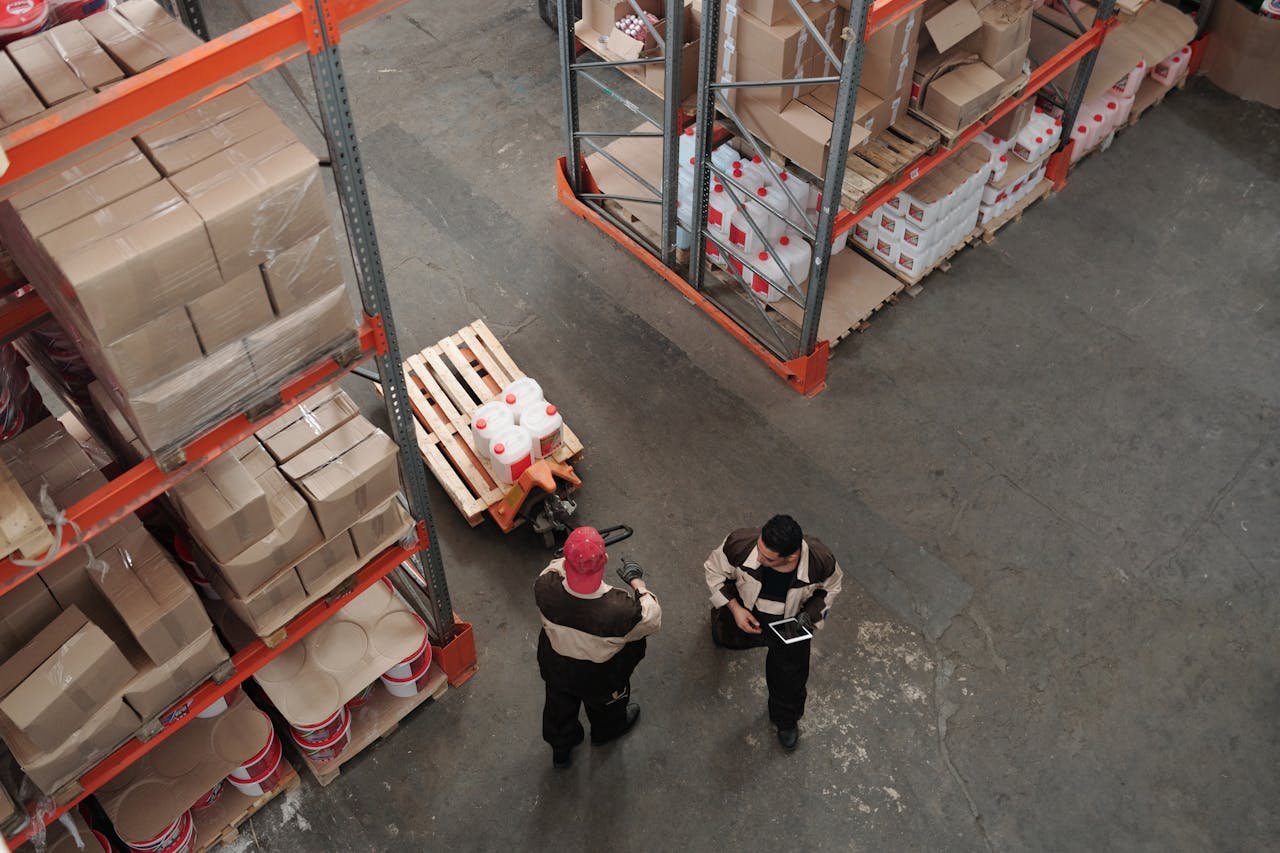 Mastering the First Impression: Your intriguing post title goes here High angle view of warehouse workers organizing inventory with pallets and shelves.