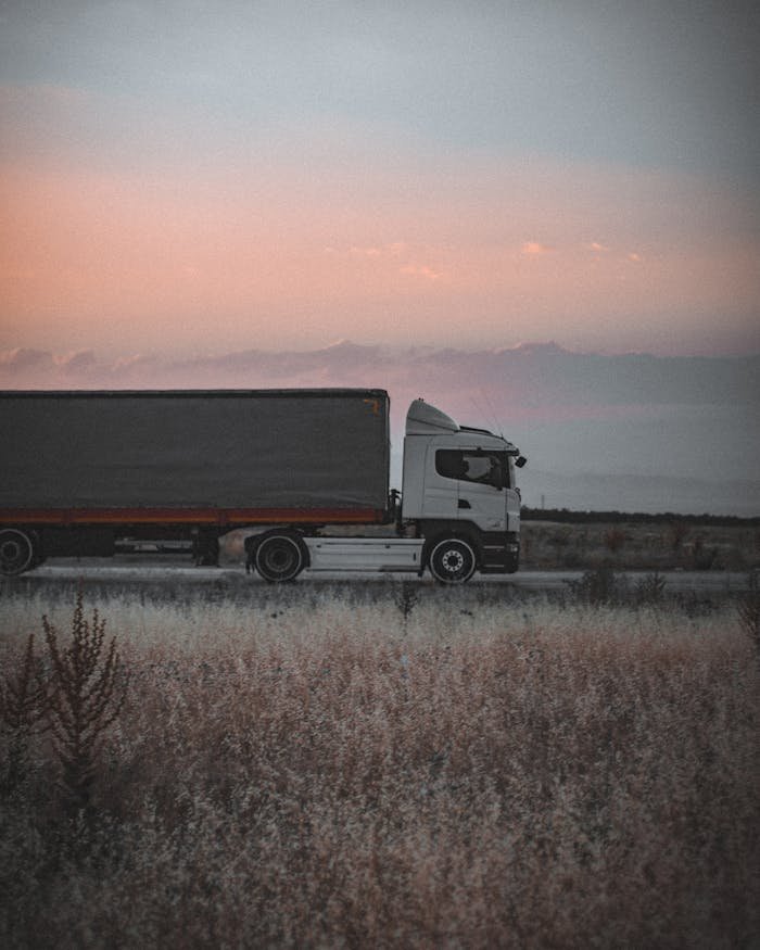 Crafting Captivating Headlines: Your awesome post title goes here A cargo truck travels on a highway at sunset, surrounded by an open landscape, symbolizing logistics and transportation.